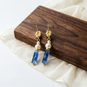Primo piano dei dettagli di orecchini pendenti stile cinese con perle e cristalli blu.