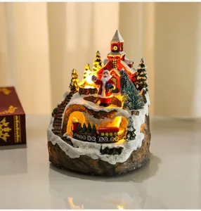 Detailed view of the Christmas resin music box ornament with Santa, church and glowing lights.