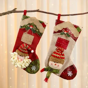 Grandes calcetines de navidad de yute vista detallada con lindo papa noel y muneco nieve.