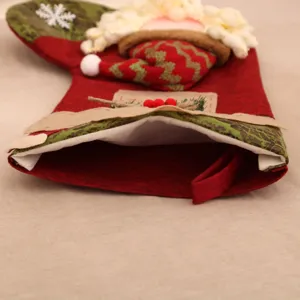 Detalle de primer plano de calcetín de Navidad de yute 3D grande con peluche de Papá Noel.
