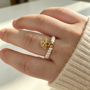 Detaillierte Ansicht eines Naturperlenrings mit drei kleinen goldenen Münzanhängern