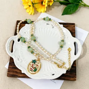 Primer plano de collar de perlas de agua dulce con jade y colgante festivo de Papá Noel.