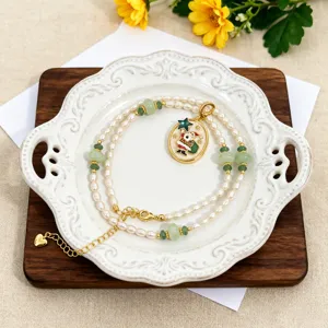 Detalle de collar de perlas de agua dulce naturales con cuentas de jade y colgante Santa