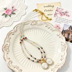 Detail van barokke parelketting met kristallen en turquoise kralen op keramisch bord