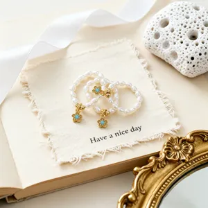 Elegantes Set aus drei Süßwasserperlen-Elastic-Ringen mit türkisen Blumenanhängern