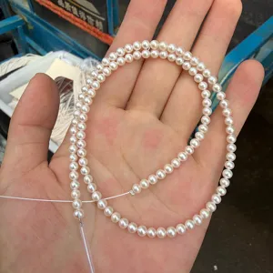 Gedetailleerd uitzicht van 3.8-4mm ronde zoetwaterparel halffabrikaat snoer voor sieraden.