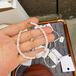 Close-up of baroque pearl bracelet with rectangular bead and gold heart charm