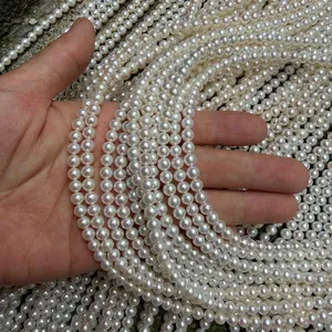 Detailopname van witte zoetwaterparelstrengen, ronde kralen voor sieraden maken.