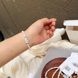 Detailed close-up of a handmade baroque pearl bracelet with a rectangular focal bead on a wrist
