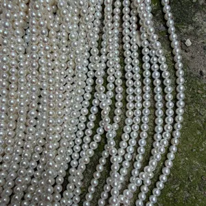 Gedetailleerd overzicht van natuurlijke zoetwaterparelstrengen, 5-5.5mm ronde witte parels.
