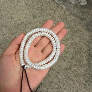 Detailed close-up shot of 7.5-8mm flat freshwater pearl beads, perfect for DIY jewelry making.