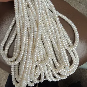 Close-up detail of natural freshwater pearl bead strands, flat disc shape for diy jewelry.