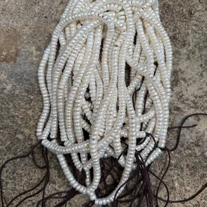 Detailed close-up of white flat-cut freshwater pearl strands for DIY jewelry making design.
