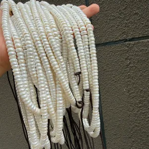 Close-up detail of white flat-cut freshwater pearl bead strands, perfect for DIY jewelry making.