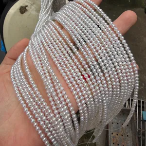 Close-up detail view of white freshwater pearl strands, small size 3-3.5mm pearls for jewelry making.