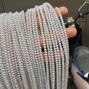 Detailed view of multiple strands of small white freshwater pearl beads hanging gracefully.