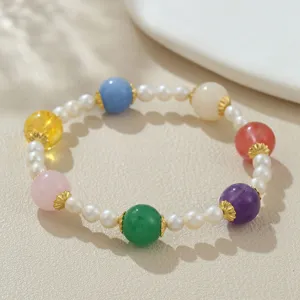 Detailansicht eines charmanten bunten Kristall und Süßwasserperlen Armbands mit goldenen Akzenten.