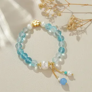 Nahaufnahme Detail des neuen chinesischen blauen Kristall und Perlen Armbands mit Goldblume.