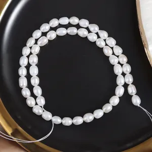 Close-up detail shot of white natural freshwater rice pearls, showing smooth luster and texture.