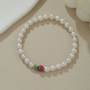 Natürliches Süßwasserperlenarmband mit bunten Zinnober- und Türkisperlen im Detail.