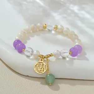 Gros plan détaillé du bracelet en perles naturelles et cristal avec charm Fu chinois.