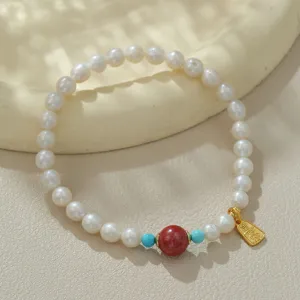 Wunderschönes Armband aus Süßwasserperlen mit roter Cinnabar-Perle und goldenem Anhänger.