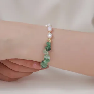 Nahaufnahme Detail von Naturperlen und gruenen Steinchips Armband am Handgelenk