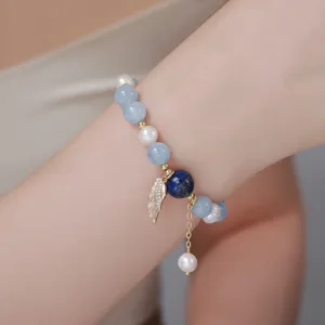 Exquisites Armband aus echten Süßwasserperlen und blauen Kristallen mit filigranem Metallflügel.