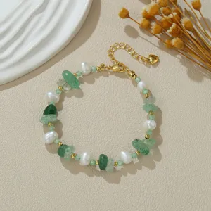Armband van natuurlijke zoetwaterparels en groene edelstenen met gouden ketting en hartje.