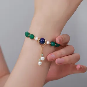 Detailaufnahme des chinesischen Perlenarmbands mit grünen und blauen Steinen, Anhänger.