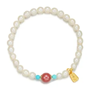 Nahaufnahme des natürlichen Süßwasserperlenarmbands mit rosa Perle und goldenem Anhänger.
