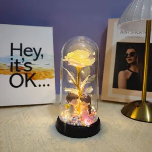 Detailed view of the romantic glass dome rose light with cute couple figures and warm LED lights.