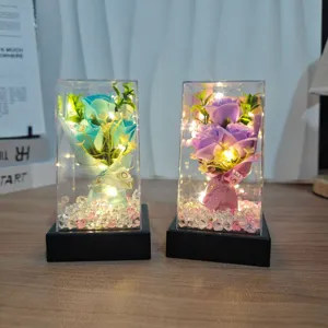 Preserved soap rose flower bouquet in clear gift box with LED lights for home decor.