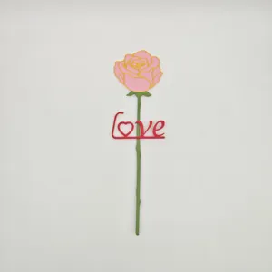 Dettaglio di magnete frigo rosa artificiale con testo love rosso, stelo decorativo creativo.