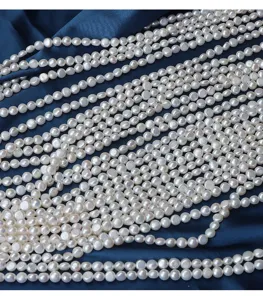Close-up detail of smooth white natural coin freshwater pearl strands for DIY jewelry making.