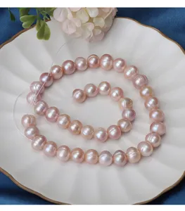 Primo piano dettagliato di perle d'acqua dolce rosa sfuse che mostrano lucentezza naturale e consistenza.