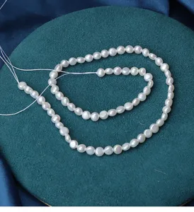 Close-up detail of white natural flat pearl loose beads for DIY jewelry making and crafting.