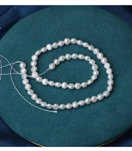 Close-up detail of smooth natural coin pearl beads strand for DIY jewelry making and crafting.