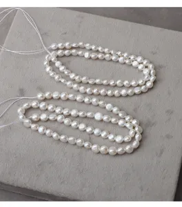 Natural freshwater coin pearl beads close-up, smooth surface texture, diy jewelry stringing detail view.