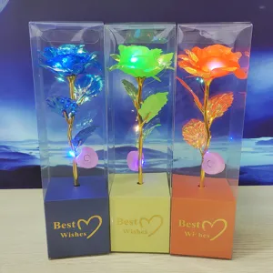 Detailed view of colorful gold foil rose with LED light in clear box gift packaging.