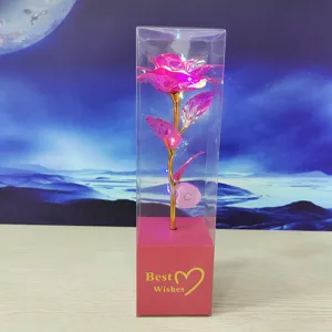 Detail shot of a colorful gold foil artificial rose with LED lights in a transparent gift box.