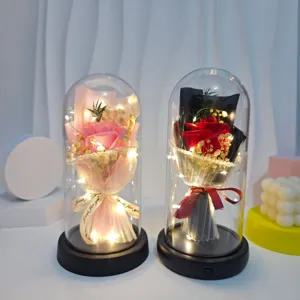 Detailed view of artificial soap rose bouquet night light with warm LED string in acrylic dome.