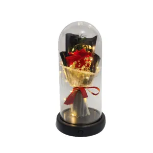 Red soap rose flower bouquet in clear glass dome with warm LED fairy lights for romantic gifts.