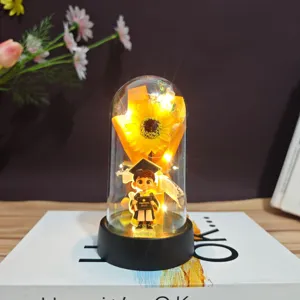 Graduation gift sunflower preserved flower night light with cute bachelor doll detail view.