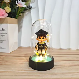 Close-up detail of graduation acrylic dome night light with LED base and cute figurine.