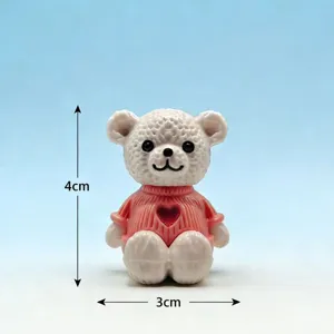 Mini figura de oso de plástico con jersey de corazón rosa, detalle de decoración.