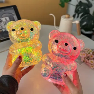 Close-up view of cute glowing bear night lights with colorful glitter inside, cozy home decor.
