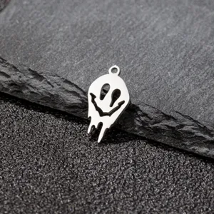 Gros plan détaillé du pendentif tête de mort souriant argenté, idéal pour la création de bijoux DIY.
