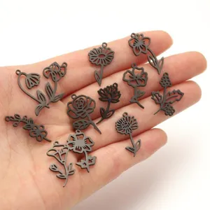 Close-up detail of black stainless steel floral hollow pendants for DIY jewelry making.