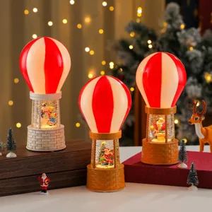 Detailed view of Christmas hot air balloon snow globe music box with water and glowing lights.